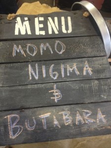 Chalk writing on the rustic menu board at Alchemy chef Ricardo Heredia's food stand lists the two types of Japanese skewers he was grilling at the Street Food Market party held in the San Diego Public Market on March 24, 2013. Momo nigma is a mix of chicken and Japanese scallions. Butabara is pork belly. (Photo by Cyndia Zwahlen for the Small Biz Mix.)