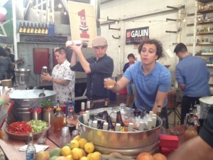 Fruit juices, herbs and veggies mix with galvanized steel tubs packed with ice, liquor, wines and local beer at the cocktail station run by the Queen-Connor-Ward Collective for the Street Food Market party at the San Diego Public Market, March 24, 2013. Jen Queen caps a cocktail shaker at left. Ian Ward, center, works another cocktail shaker while Justin Hockemeyer, right, leans out to offer a citrus-garnished drink. (Photo by Cyndia Zwahlen for the Small Biz Mix)
