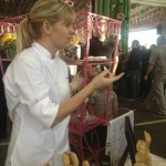 Pastry chef Jennifer Costa-Stines of the A.R. Valentien restaurant at the Lodge at Torrey Pines in La Jolla, Calif., gestures behind her table of pie pops at the Street Food Market party held at the San Diego Public Market, March 24, 2013. Her mini pies on lollipop sticks hid sweet fillings such as a rosy strawberry-rhubarb as well as savory ones such as duck. (Photo by Cyndia Zwahlen for the Small Biz Mix)