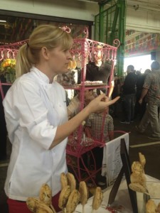 Pastry chef Jennifer Costa-Stines of the A.R. Valentien restaurant at the Lodge at Torrey Pines in La Jolla, Calif., gestures behind her table of pie pops at the Street Food Market party held at the San Diego Public Market, March 24, 2013. Her mini pies on lollipop sticks hid sweet fillings such as a rosy strawberry-rhubarb as well as savory ones such as duck. (Photo by Cyndia Zwahlen for the Small Biz Mix)
