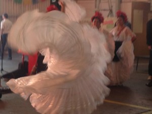 A spiral swirl of white ruffles is almost all there is to see of this Ballet Folklorico dancer from DanzArts of San Diego, one of the entertainers at the Street Food Market party held March 24, 2013 in the San Diego Public Market. (Photo by Cyndia Zwahlen for the Small Biz Mix.)