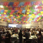 Rows of colorful Mexican paper banners (papel picado) wave overhead in the smoky air as hundreds of partygoers sample the goodies at the Street Food Market party held March 24, 2013 at the cavernous San Diego Public Market. (Photo by Cyndia Zwahlen for the Small Biz Mix.)